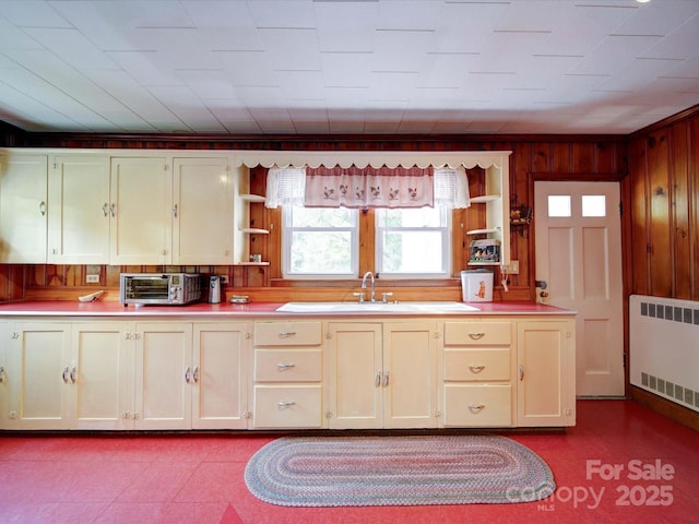 1614 Linwood Rd, Gaston, NC 28052 - kitchen featuring open shelves, radiator, a sink, wood walls, and light countertops