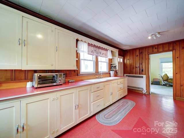1614 Linwood Rd, Gaston, NC 28052 - kitchen with radiator, a sink, dark flooring, light countertops, and wood walls