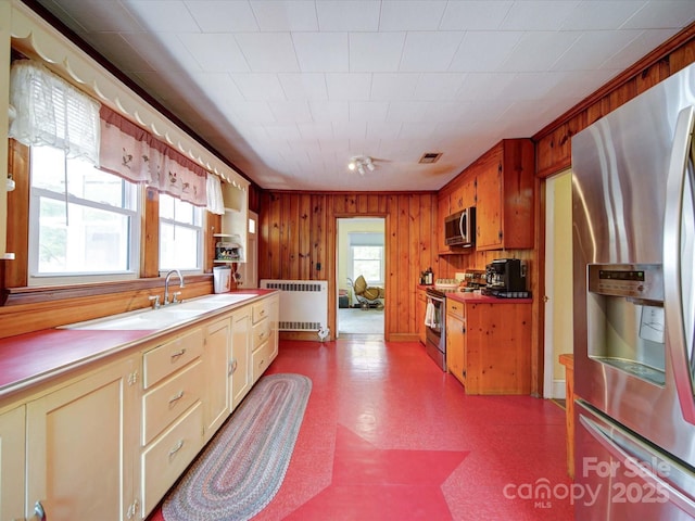 1614 Linwood Rd, Gaston, NC 28052 - kitchen featuring appliances with stainless steel finishes, radiator heating unit, tile patterned floors, wooden walls, and a sink