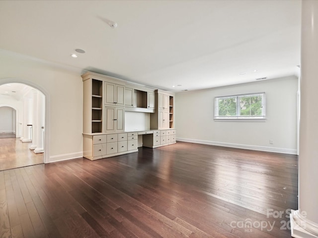 4300 Cameron Oaks Dr, Charlotte, NC 28211 - unfurnished living room with arched walkways, dark wood finished floors, recessed lighting, and built in desk