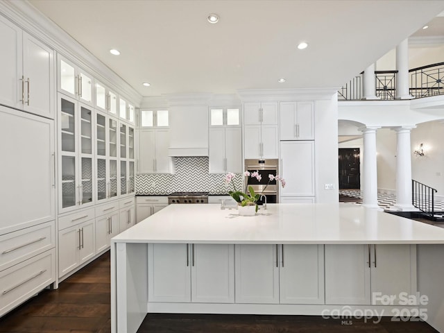 4300 Cameron Oaks Dr, Charlotte, NC 28211 - kitchen with ornate columns, stainless steel double oven, a large island with sink, white cabinets, and recessed lighting
