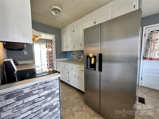 178 Cedar Valley Rd, Hudson, NC 28638 - kitchen with stainless steel fridge, black electric stovetop, white cabinetry, light countertops, and a textured ceiling