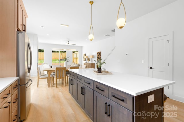 2413 Pruitt St, Charlotte, NC 28208 - kitchen featuring freestanding refrigerator, light wood-style floors, light countertops, and hanging light fixtures