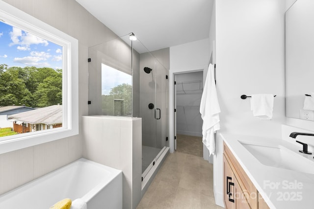 2413 Pruitt St, Charlotte, NC 28208 - bathroom with a stall shower, double vanity, a garden tub, a walk in closet, and tile patterned floors