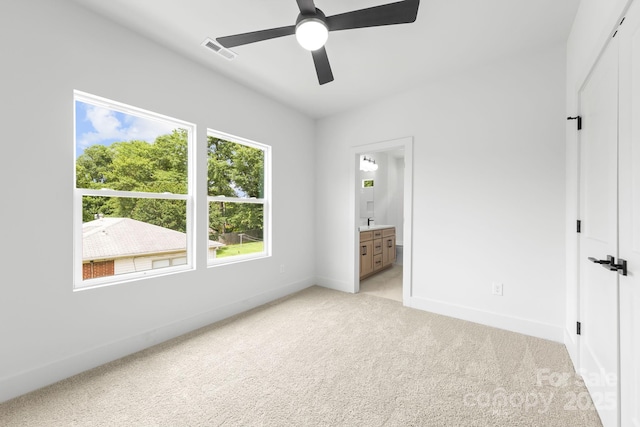 2413 Pruitt St, Charlotte, NC 28208 - unfurnished bedroom with light carpet, ensuite bathroom, and a ceiling fan