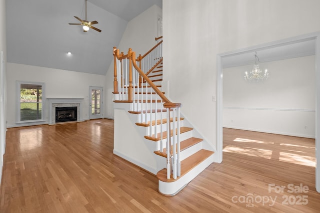 765 Portpatrick Pl, Fort Mill, SC 29708 - stairway with high vaulted ceiling, a ceiling fan, wood finished floors, a premium fireplace, and a chandelier