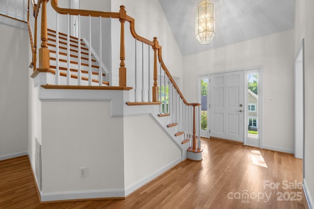 765 Portpatrick Pl, Fort Mill, SC 29708 - foyer entrance with wood finished floors, high vaulted ceiling, stairway, baseboards, and a chandelier