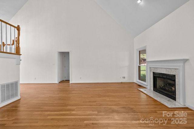 765 Portpatrick Pl, Fort Mill, SC 29708 - unfurnished living room featuring high vaulted ceiling, a high end fireplace, light wood-style floors, and baseboards