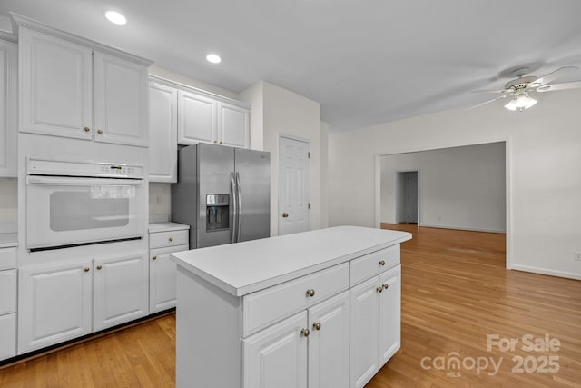 765 Portpatrick Pl, Fort Mill, SC 29708 - kitchen with white oven, stainless steel fridge, ceiling fan, light countertops, and a center island