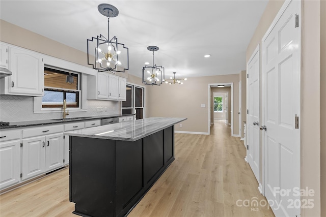 5916 Cashion Rd, Huntersville, NC 28078 - kitchen featuring a sink, a chandelier, tasteful backsplash, dark stone counters, and a center island