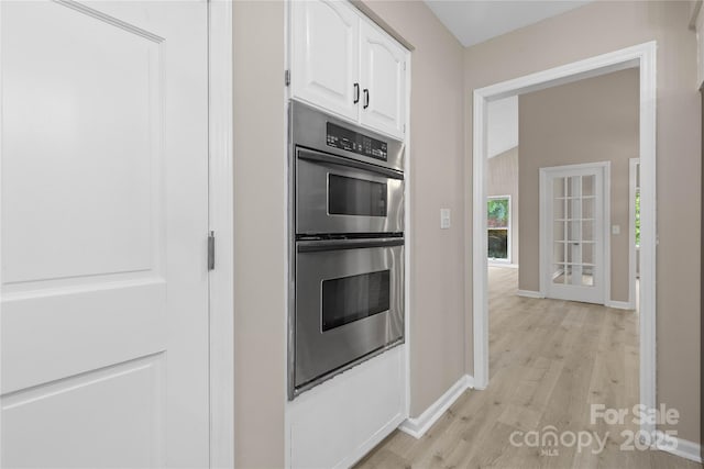 5916 Cashion Rd, Huntersville, NC 28078 - kitchen with double oven, white cabinets, light wood-type flooring, and baseboards