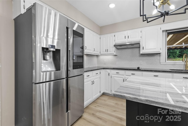 5916 Cashion Rd, Huntersville, NC 28078 - kitchen featuring stainless steel fridge with ice dispenser, a sink, under cabinet range hood, white cabinetry, and dark stone countertops