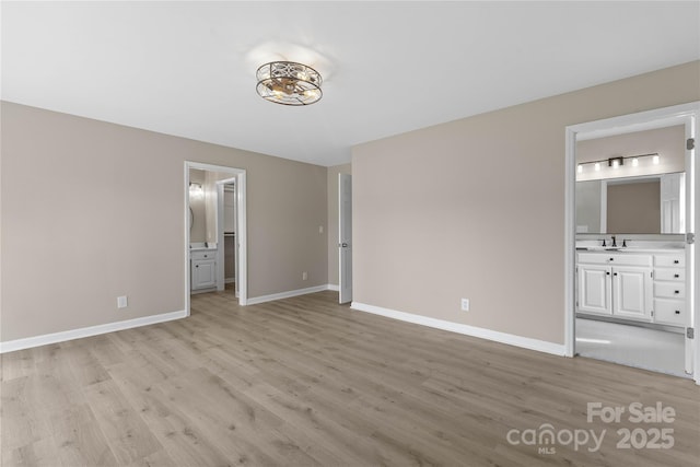 5916 Cashion Rd, Huntersville, NC 28078 - unfurnished bedroom featuring ensuite bath, light wood finished floors, a sink, and baseboards