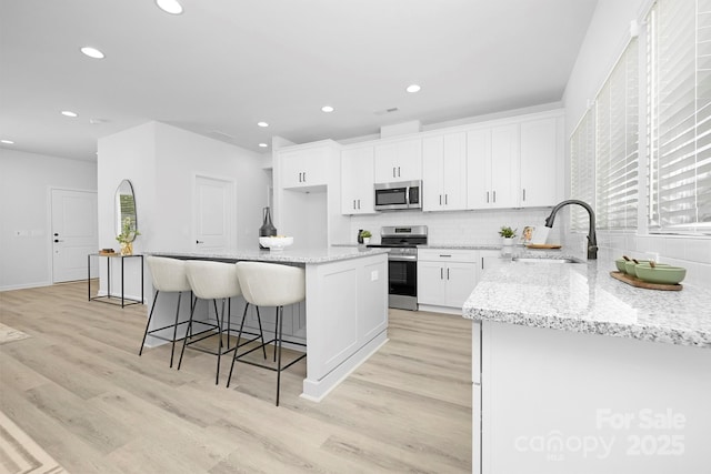 1312 W Monroe Rd, Salisbury, NC 28144 - kitchen featuring stainless steel appliances, a center island, light wood-style floors, white cabinets, and recessed lighting