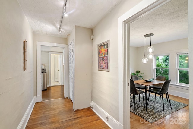 113 4th St, Black Mountain, NC 28711 - corridor featuring a textured ceiling, light wood-type flooring, baseboards, and rail lighting