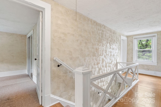 113 4th St, Black Mountain, NC 28711 - stairs featuring a textured ceiling, baseboards, wallpapered walls, and wood finished floors
