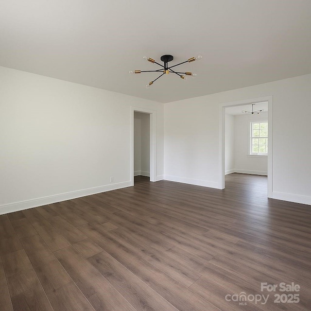 905 Gantt St, Kings Mountain, NC 28086 - unfurnished room with a chandelier, dark wood-style flooring, and baseboards