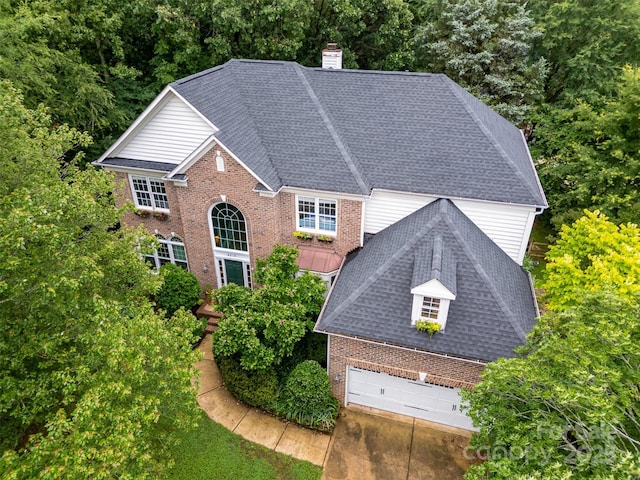 8219 Beardsley Dr, Charlotte, NC 28269 - view of front of house with brick siding, a chimney, a garage, and roof with shingles
