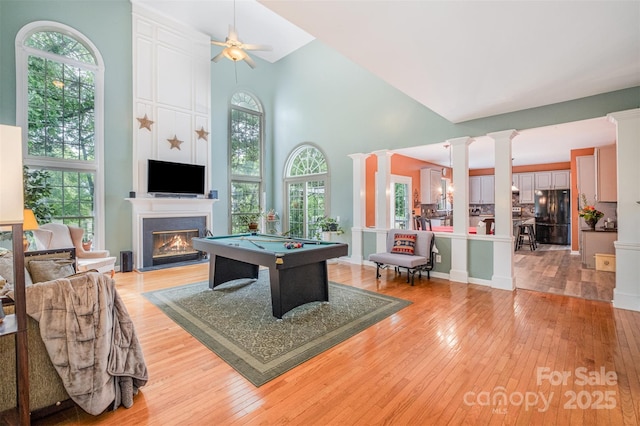 8219 Beardsley Dr, Charlotte, NC 28269 - recreation room featuring a high ceiling, light wood-style floors, a glass covered fireplace, ornate columns, and pool table