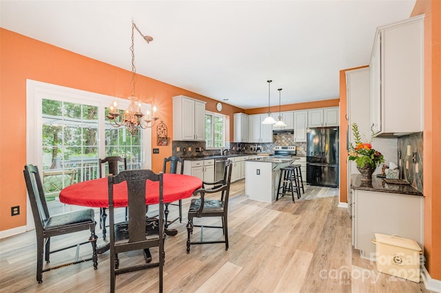8219 Beardsley Dr, Charlotte, NC 28269 - dining space featuring a chandelier, light wood-style floors, and baseboards