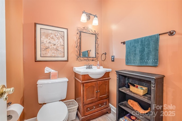 8219 Beardsley Dr, Charlotte, NC 28269 - half bathroom featuring vanity, toilet, and baseboards