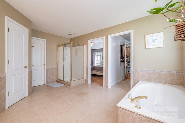 8219 Beardsley Dr, Charlotte, NC 28269 - full bathroom with a garden tub, a shower stall, tile patterned flooring, tile walls, and a spacious closet