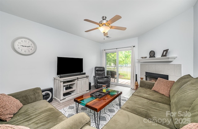 18741 Nautical Dr Unit 205, Cornelius, NC 28031 - living area with light wood-style floors, ceiling fan, a tiled fireplace, and baseboards