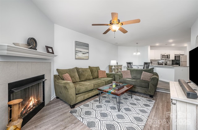 18741 Nautical Dr Unit 205, Cornelius, NC 28031 - living room featuring light wood-type flooring, ceiling fan, a tiled fireplace, and recessed lighting