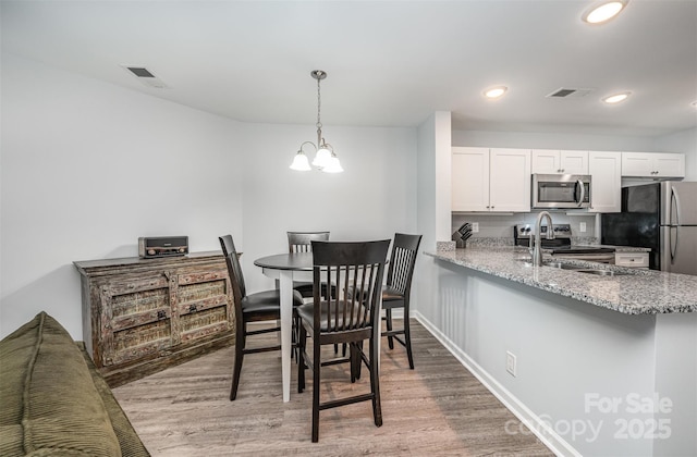 18741 Nautical Dr Unit 205, Cornelius, NC 28031 - dining space featuring light wood finished floors, a chandelier, recessed lighting, and baseboards