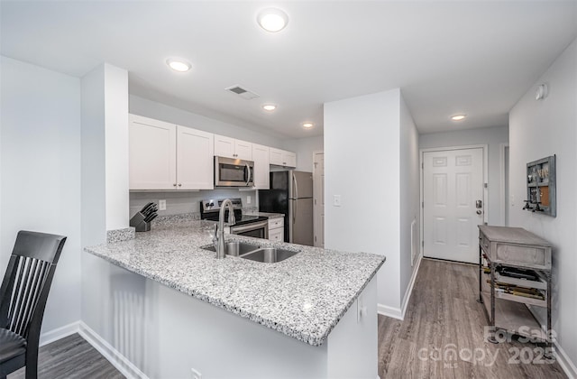18741 Nautical Dr Unit 205, Cornelius, NC 28031 - kitchen with appliances with stainless steel finishes, baseboards, a sink, wood finished floors, and white cabinets
