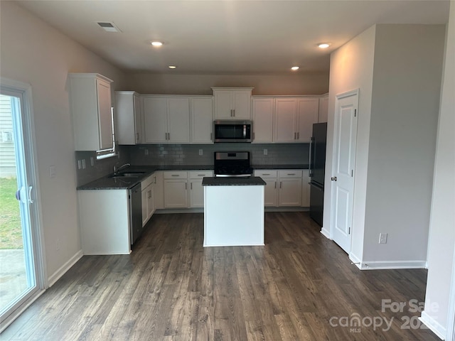 9730 Tea Garden Dr, Gastonia, NC 28056 - kitchen featuring stainless steel appliances, a sink, dark wood-style flooring, tasteful backsplash, and white cabinetry
