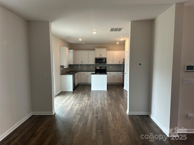 9730 Tea Garden Dr, Gastonia, NC 28056 - kitchen featuring stainless steel appliances, dark wood finished floors, dark countertops, backsplash, and white cabinets