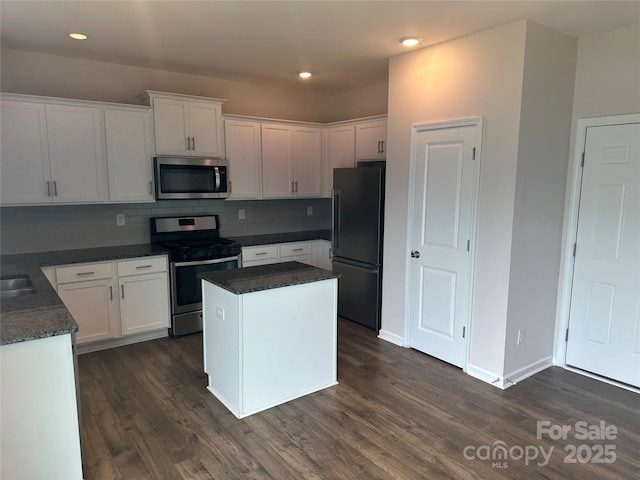 9730 Tea Garden Dr, Gastonia, NC 28056 - kitchen with appliances with stainless steel finishes, white cabinetry, dark wood finished floors, backsplash, and recessed lighting