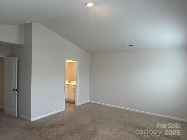 9730 Tea Garden Dr, Gastonia, NC 28056 - unfurnished bedroom featuring carpet floors, vaulted ceiling, baseboards, connected bathroom, and a sink
