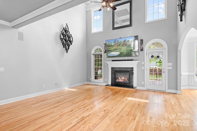 9112 Butterfly Ct, Gastonia, NC 28056 - unfurnished living room featuring a ceiling fan, ornamental molding, a fireplace, wood finished floors, and a high ceiling