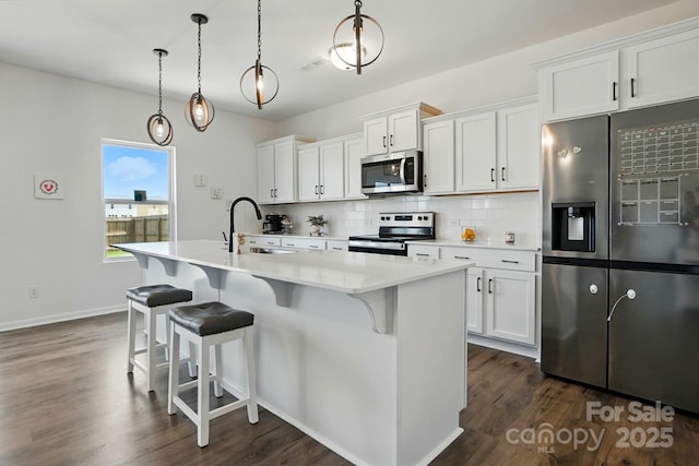 133 Aspire Cir, Wingate, NC 28174 - kitchen with stainless steel appliances, tasteful backsplash, dark wood-style floors, and a kitchen island with sink