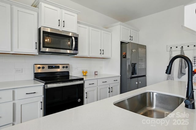 133 Aspire Cir, Wingate, NC 28174 - kitchen with appliances with stainless steel finishes, a sink, light countertops, tasteful backsplash, and white cabinetry