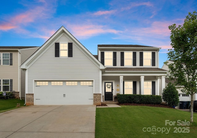 204 Fesperman Cir, Troutman, NC 28166 - traditional-style house featuring driveway, a lawn, a garage, brick siding, and covered porch