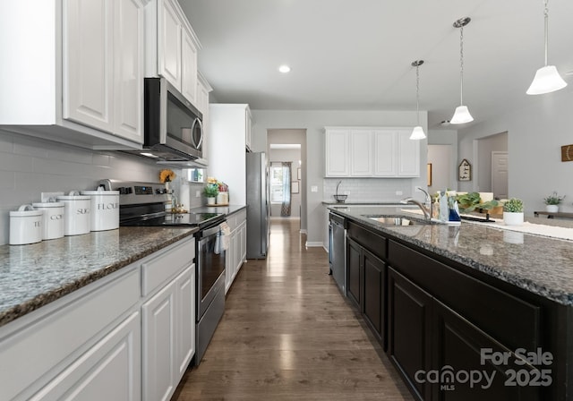 204 Fesperman Cir, Troutman, NC 28166 - kitchen featuring stainless steel appliances, white cabinets, tasteful backsplash, dark wood finished floors, and dark cabinetry