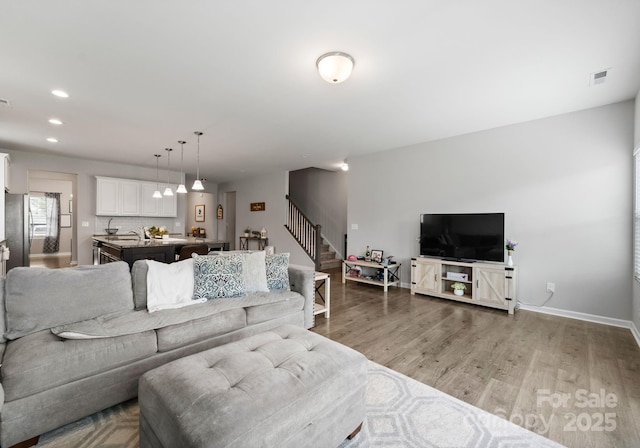 204 Fesperman Cir, Troutman, NC 28166 - living room with stairway, light wood finished floors, and recessed lighting