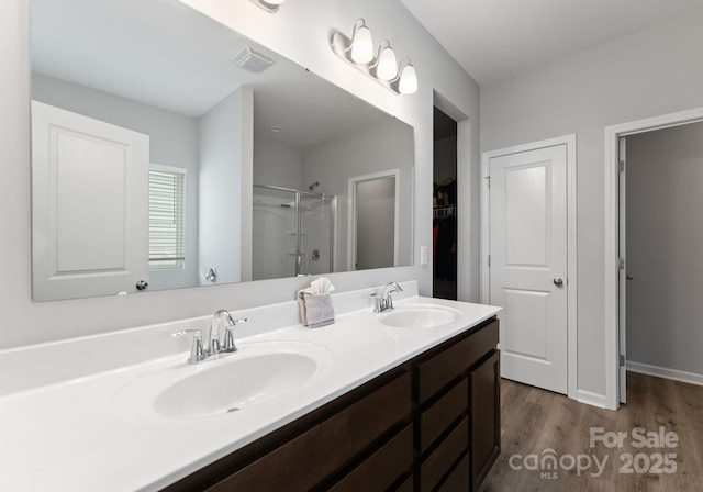 204 Fesperman Cir, Troutman, NC 28166 - full bathroom featuring wood finished floors, double vanity, a shower, and a spacious closet