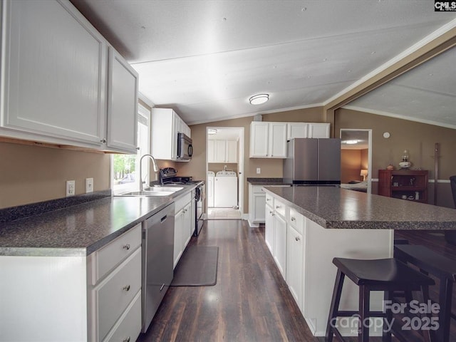 1989 White Oak Rd, Camden, SC 29020 - kitchen featuring appliances with stainless steel finishes, a sink, washing machine and dryer, dark countertops, and vaulted ceiling