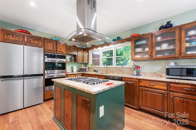 58 Campbell Creek Rd, Maggie Valley, NC 28751 - kitchen with appliances with stainless steel finishes, island exhaust hood, light wood-style flooring, light stone countertops, and glass insert cabinets