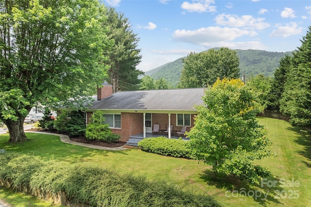 58 Campbell Creek Rd, Maggie Valley, NC 28751 - ranch-style home featuring a chimney, a front yard, a mountain view, and brick siding