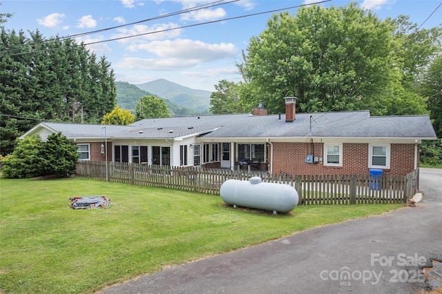 58 Campbell Creek Rd, Maggie Valley, NC 28751 - ranch-style house featuring a chimney, brick siding, a mountain view, and a fenced front yard