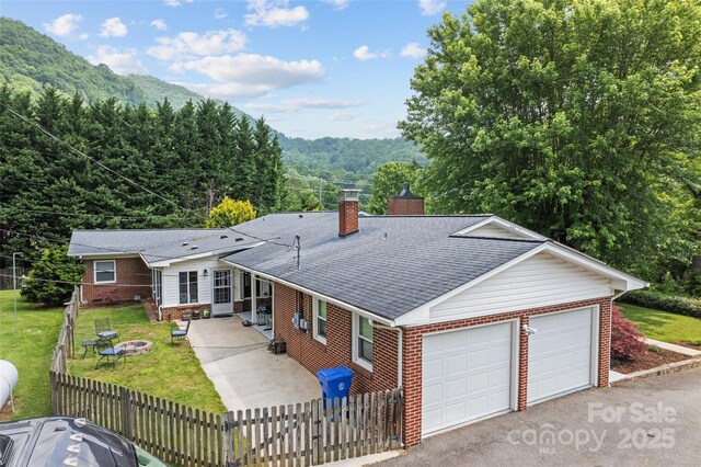 58 Campbell Creek Rd, Maggie Valley, NC 28751 - single story home with brick siding, an attached garage, an outdoor fire pit, and a chimney