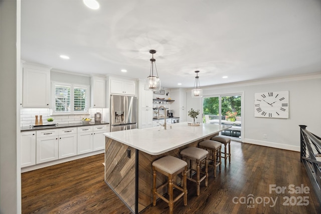 2004 Marquesas Ave, Tega Cay, SC 29708 - kitchen featuring stainless steel fridge with ice dispenser, a breakfast bar area, dark wood-style floors, backsplash, and white cabinets
