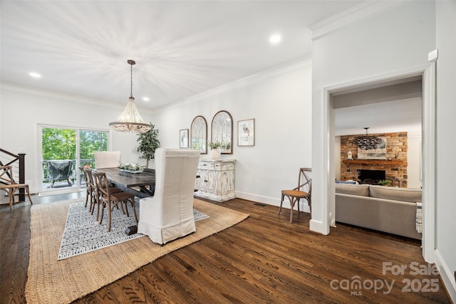 2004 Marquesas Ave, Tega Cay, SC 29708 - dining space featuring dark wood-type flooring, crown molding, a fireplace, recessed lighting, and a chandelier