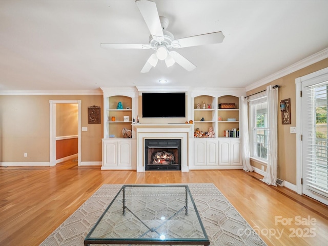 2442 Singleton Pt Unit 67, Liberty Hill, SC 29074 - unfurnished living room featuring light wood-style flooring, a warm lit fireplace, crown molding, and a ceiling fan
