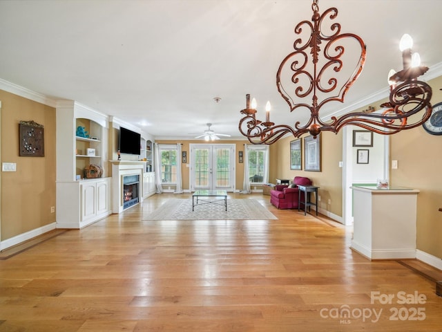 2442 Singleton Pt Unit 67, Liberty Hill, SC 29074 - unfurnished living room featuring a ceiling fan, a warm lit fireplace, light wood-type flooring, crown molding, and a chandelier